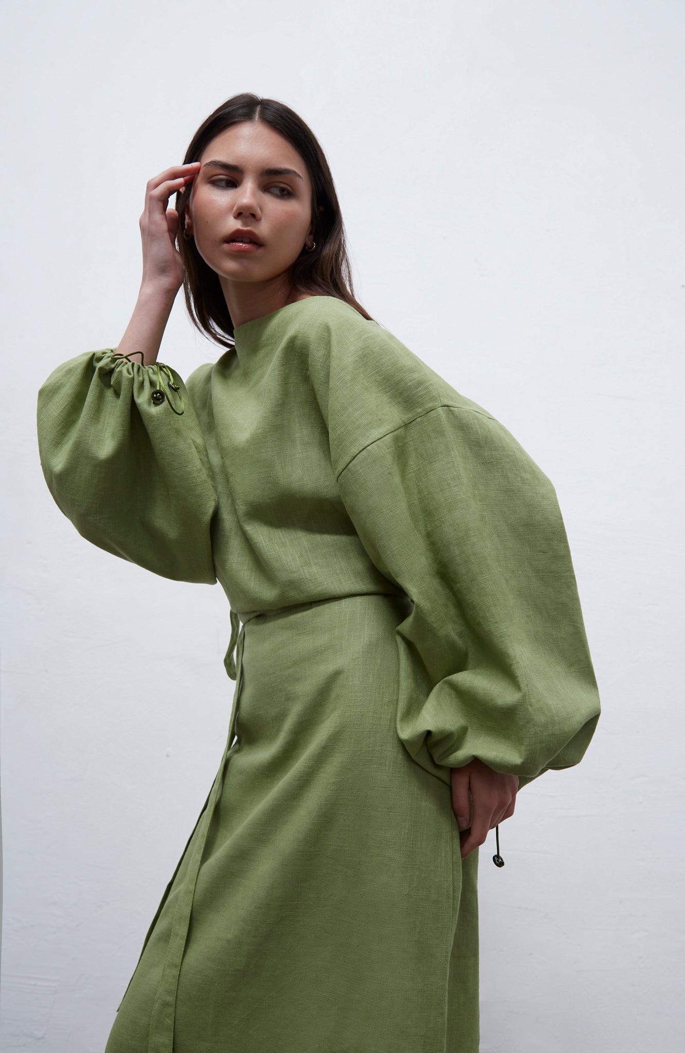 Loïe kiwi green loose-fit linen dress with adjustable side ties and puff sleeve detail, handmade in Barcelona